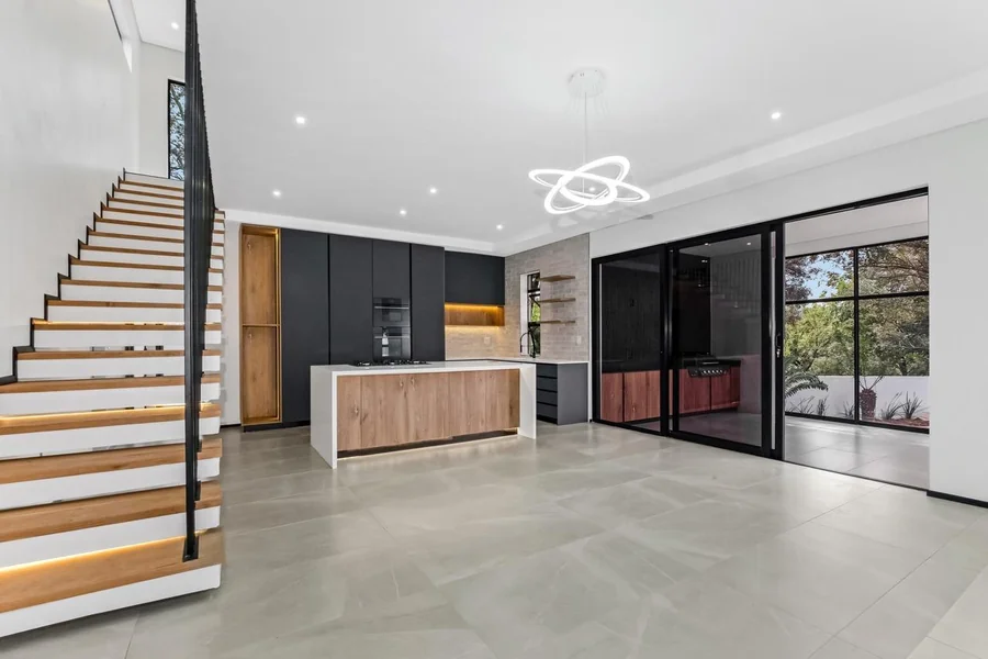 Helderfontein kitchen and staircase with a central island, black cabinetry, open-riser stairs and garden views.