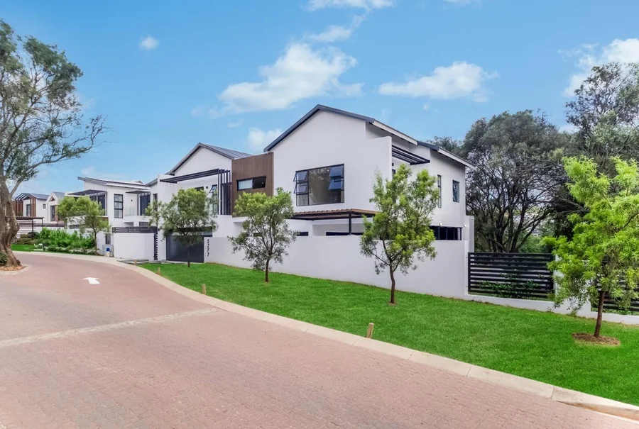 Helderfontein homes along a landscaped residential street beneath a blue sky.